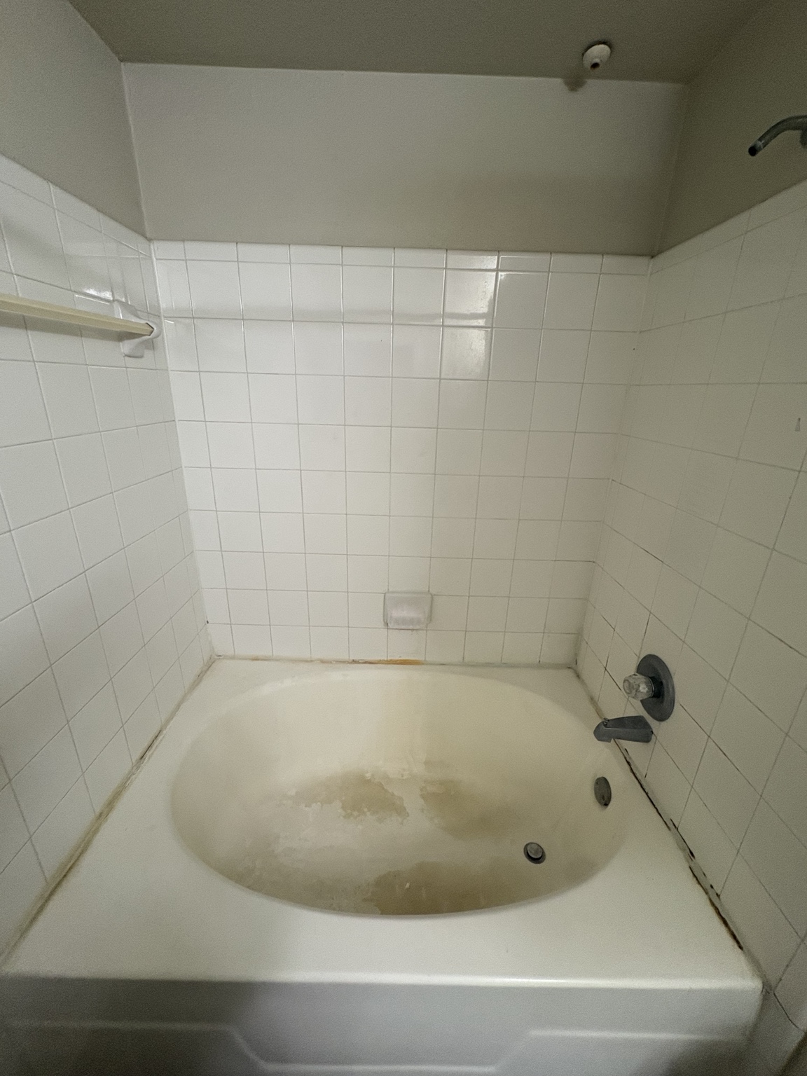 White tile bathtub before deep cleaning